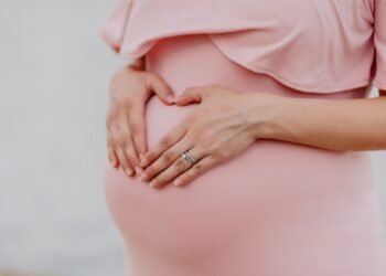 woman wearing gold ring and pink dress