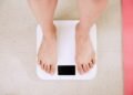 person standing on white digital bathroom scale